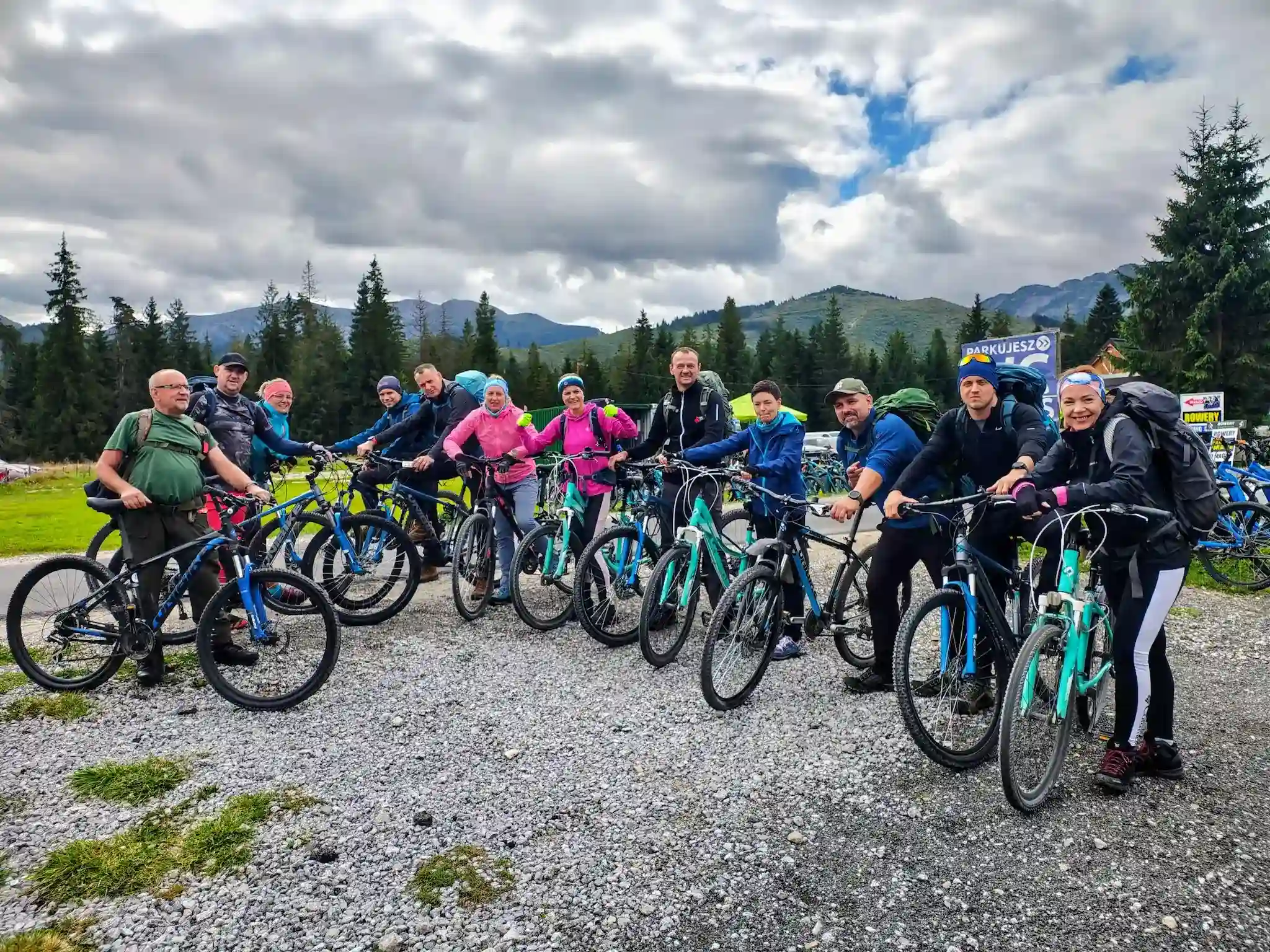 Klienci przy rowerach na tle gor